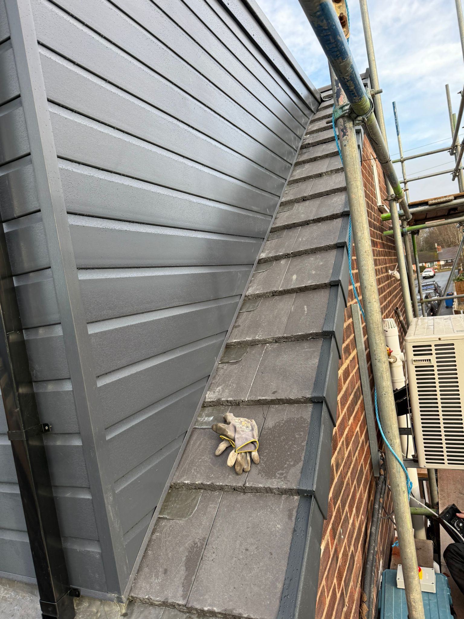 Exterior wall cladding with repair work exposed