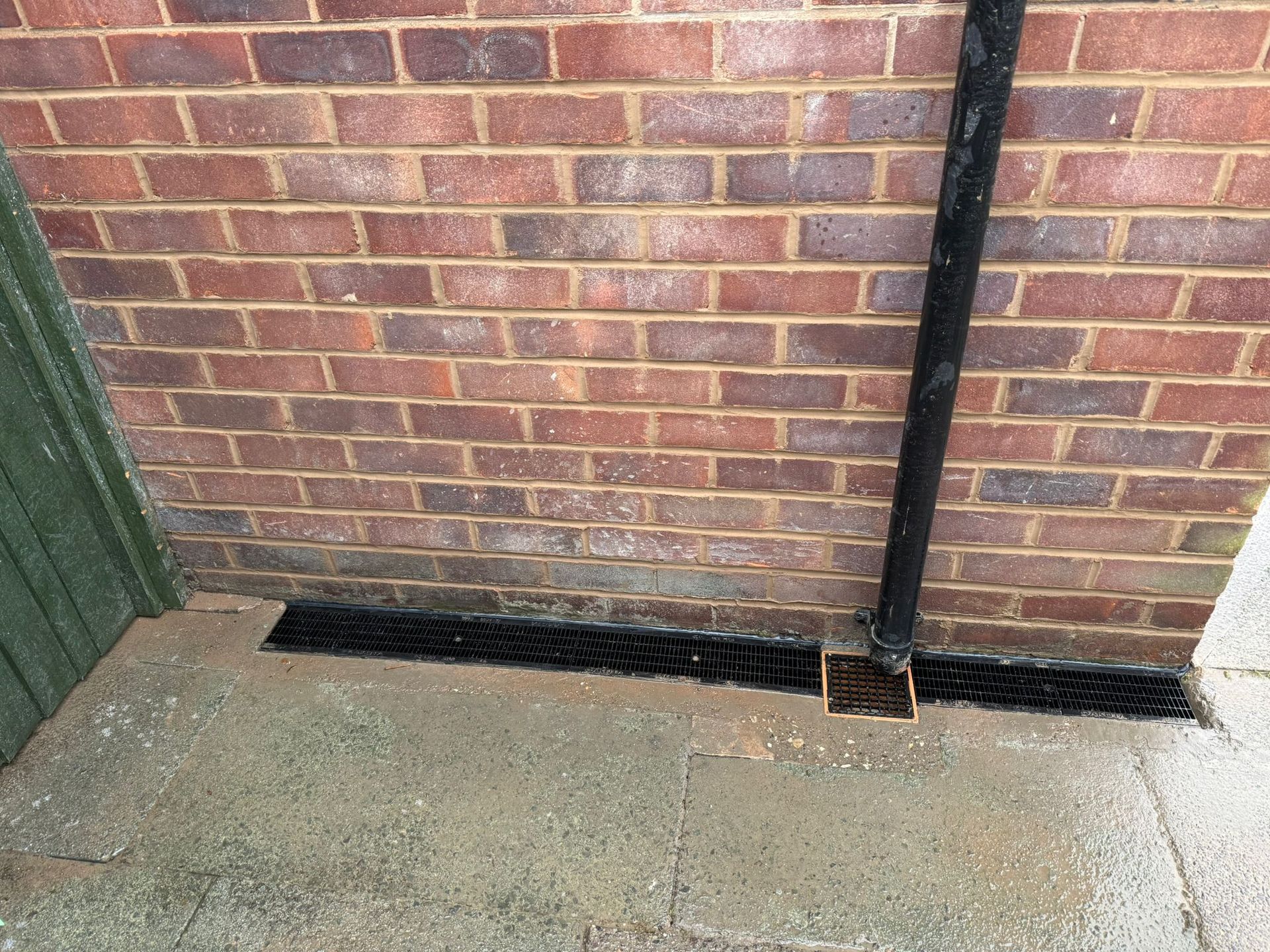 Drainage channel beside a brick wall