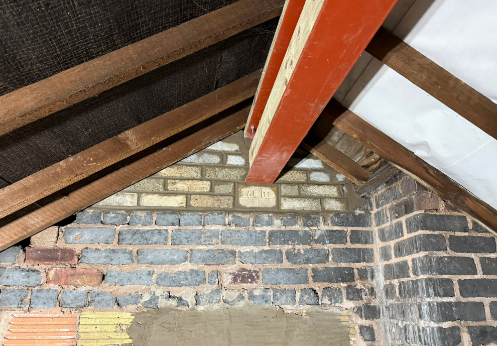 Timber roof detail above a brick wall