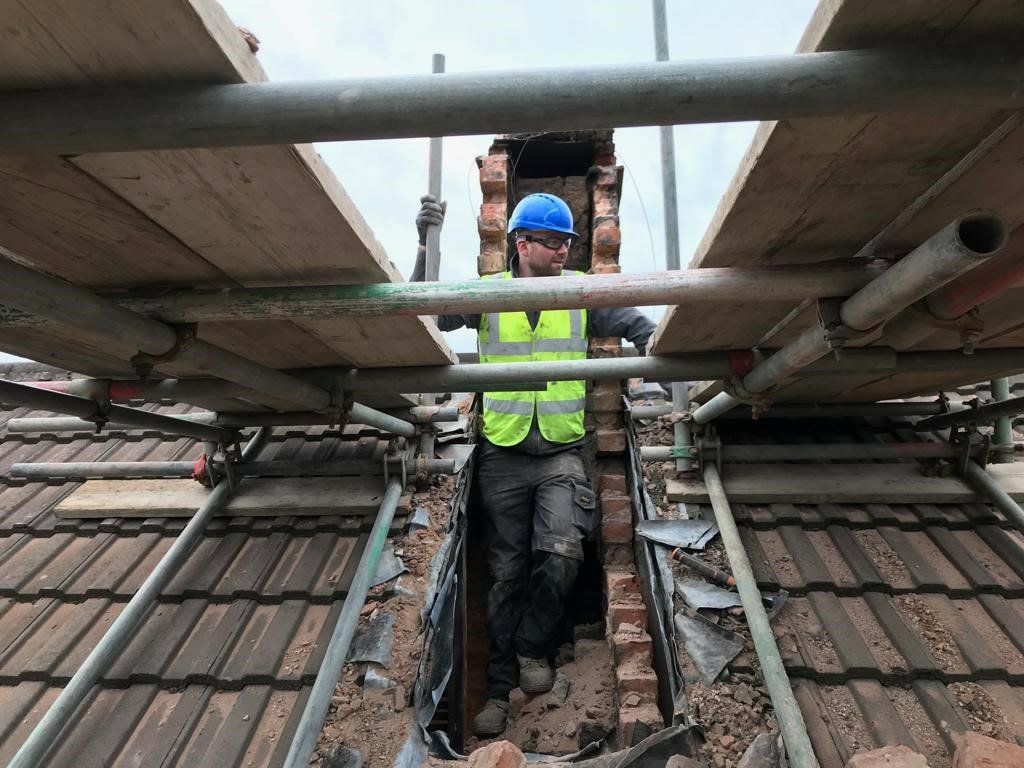 Residential roof structure being worked on by a tradesperson